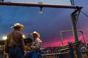 Cowboys chat during a rodeo.